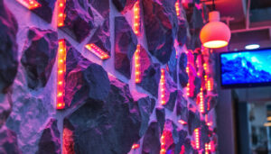 A photograph of a modern rock panel wall integrated with vibrant led displays