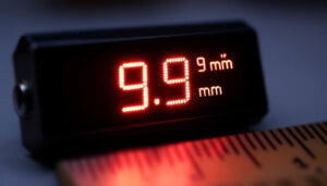 A photograph of a close-up of an led display showing measurements in both millimeters and inches