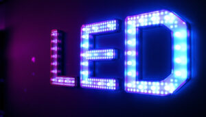 A photograph of a vibrant pink led sign glowing against a dark backdrop