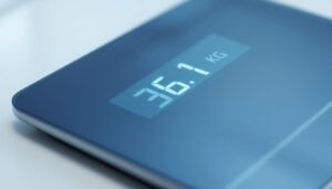 A photograph of a sleek digital scale displaying the conversion of 36.1 kilograms to pounds
